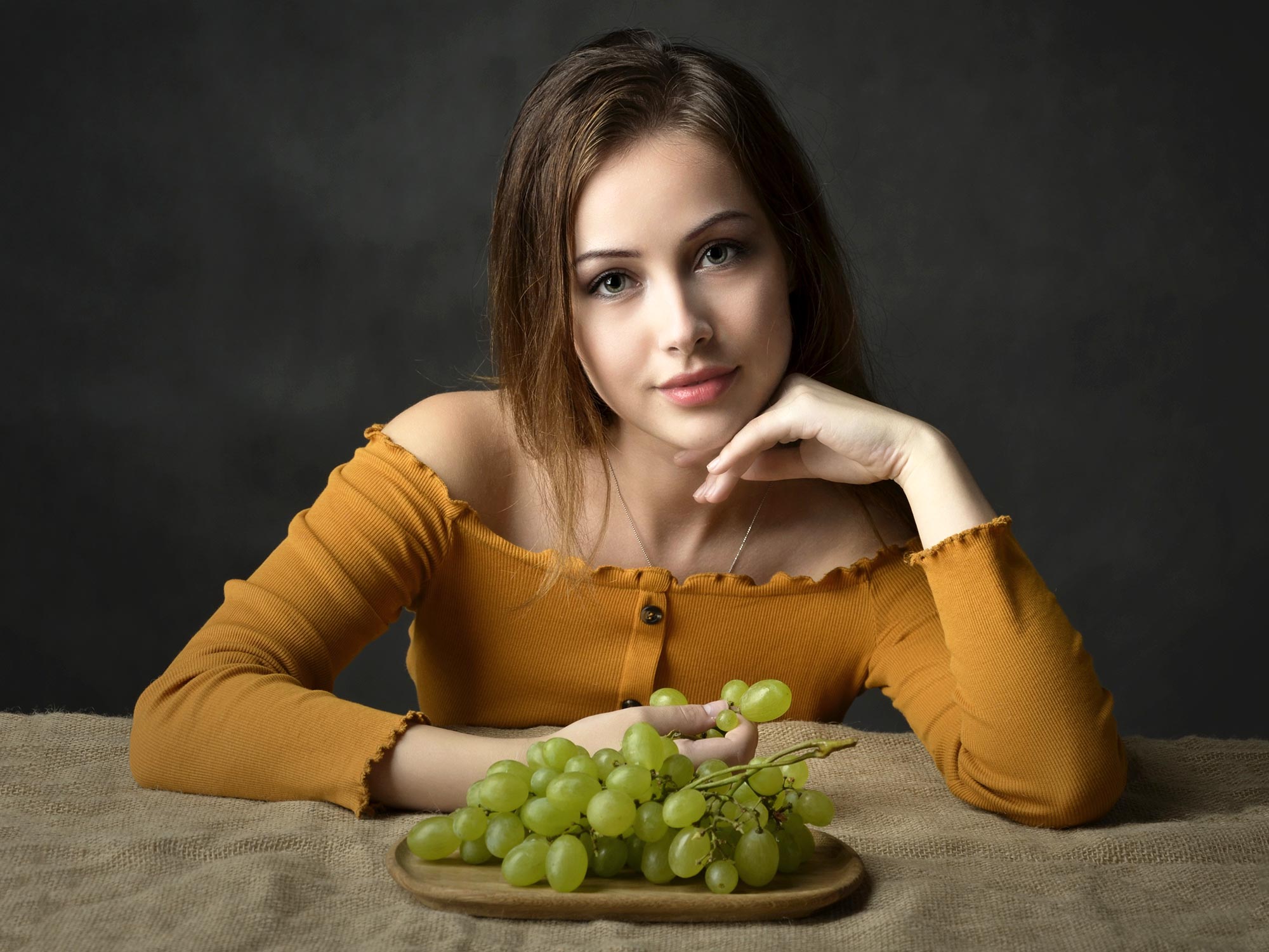 Красивая модель позирует с виноградом