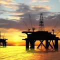 Oil rig silhouette over orange