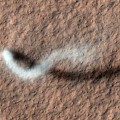 towering dust devil casts a serpentine shadow over the Martian surface