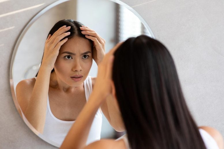Asian Woman Examining Hair Mirror Concern