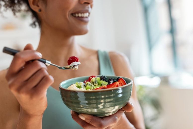 Athletic Woman Eating Healthy Fruit Bowl