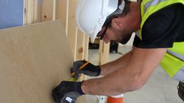 Builder Measuring Plasterboard