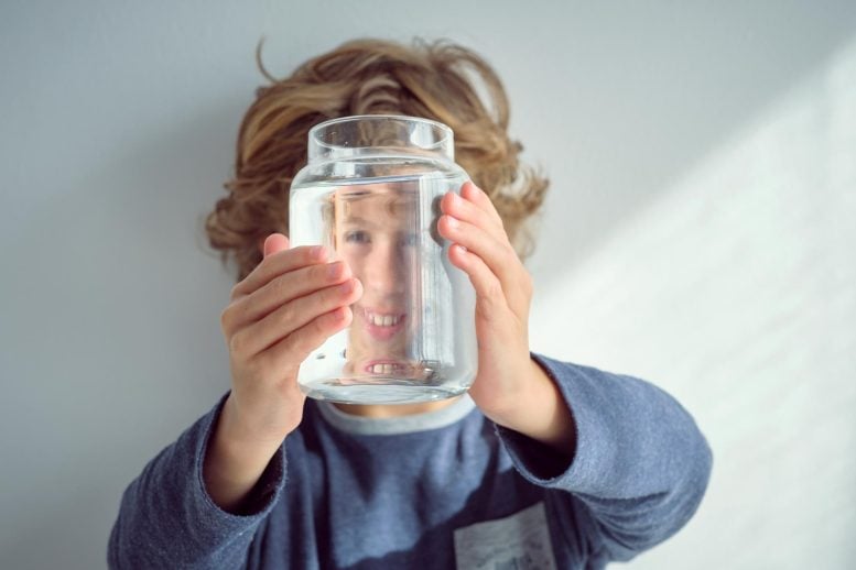 Cheerful Kid Looking Glass Bottle Filled Clean Water