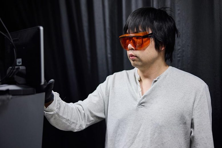 Chenjia Mi Takes a Measurement on a Microscope