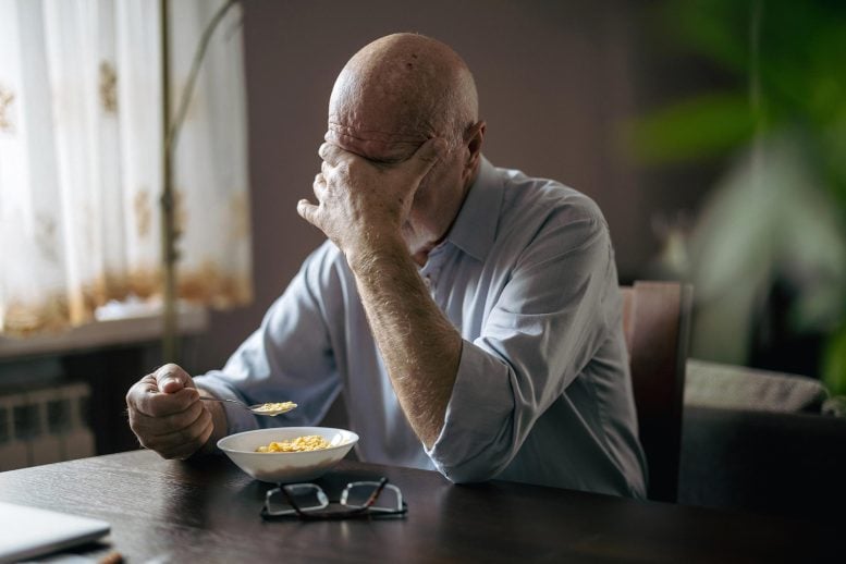Depressed Senior Man Eating Breakfast Alone