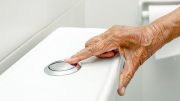 Elderly Woman Flushing Toilet