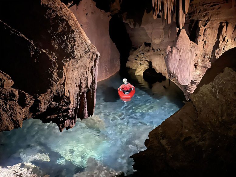 Explorer Kayaking in Flooded Cave Chamber