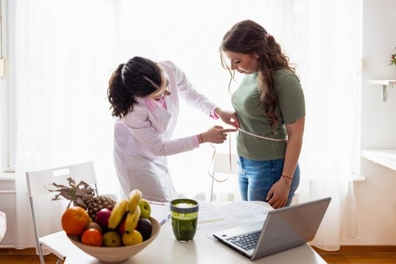 Female Doctor Weighing Patient