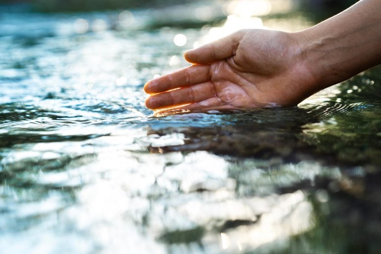 Female Hand Touching River Water