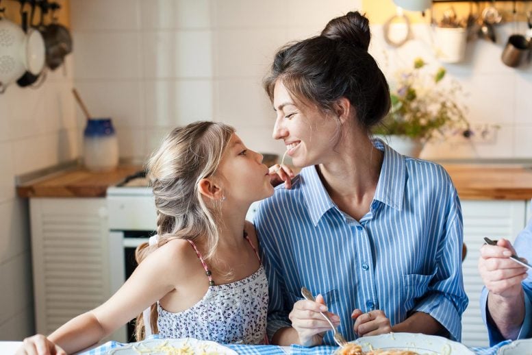 Happy Mother Daughter Sharing Spaghetti Eating Dinner
