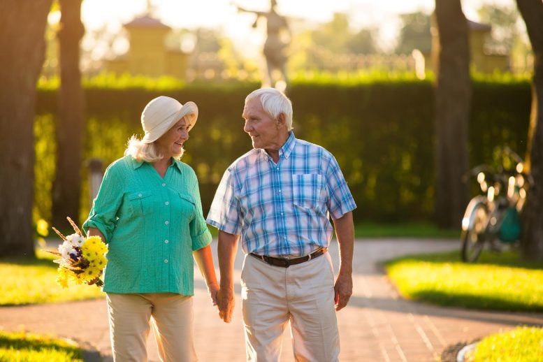 Happy senior couple holding hands walking