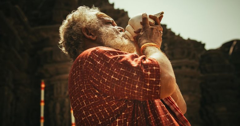 Indian Man Blowing Through Conch Shell