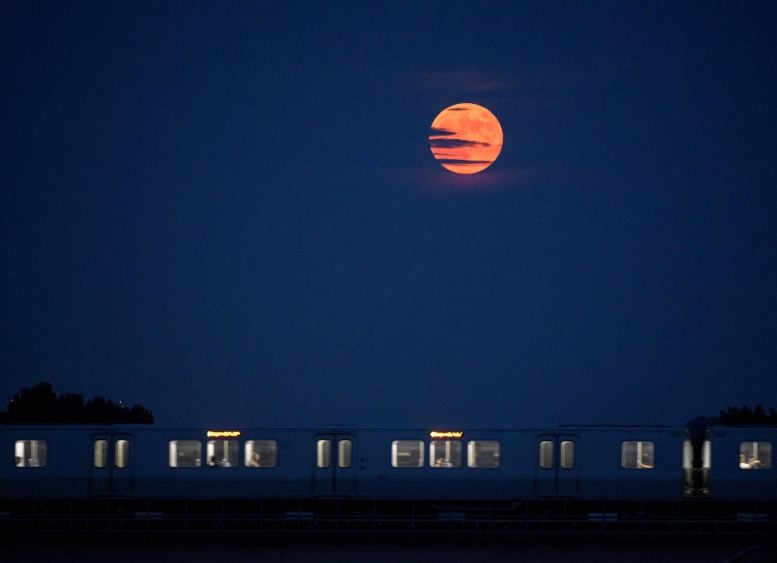 The Moon rises as a Metrorail car crosses the Potomac River in Washington D.C. on July 16, 2019