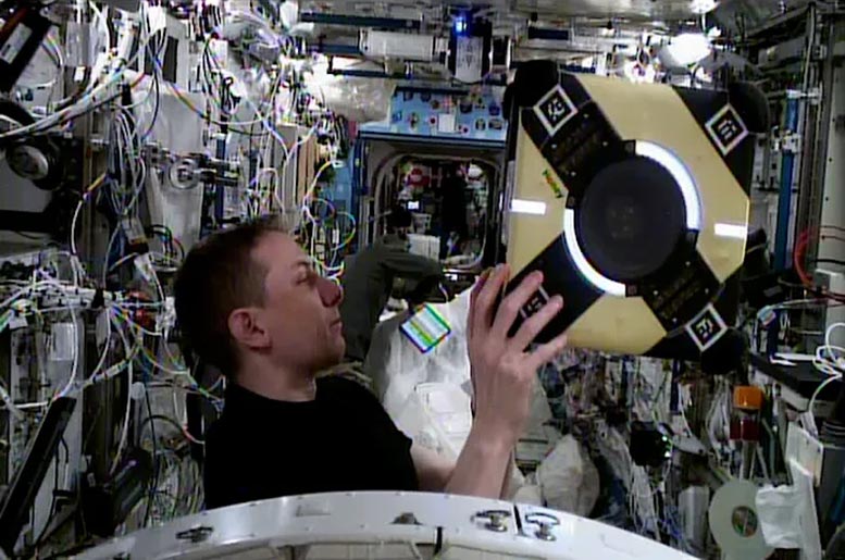 NASA Astronaut Woody Hoburg Examines Astrobee Free-Flying Robot