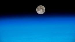 Near Full Moon Just Above Earth’s Atmosphere
