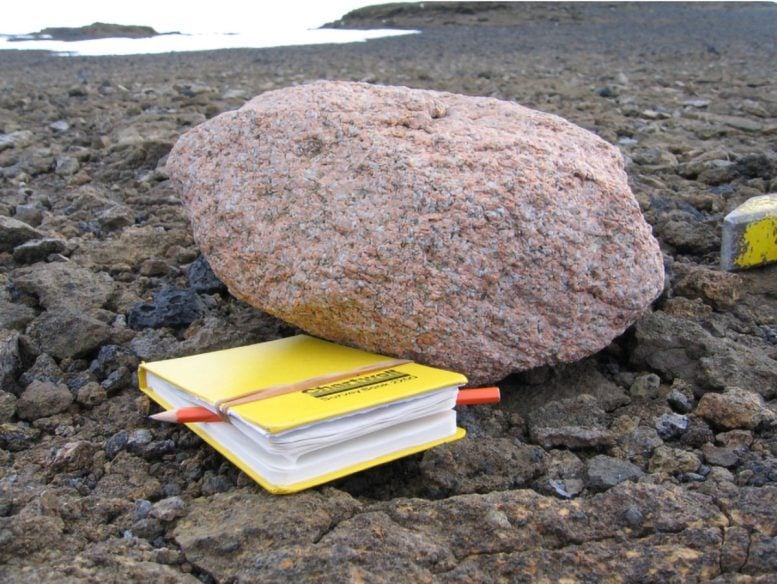 Pink Granite Boulder Next to a Yellow Notebook