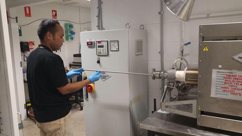 Researcher Placing Regolith Simulant Into Laboratory Furnace