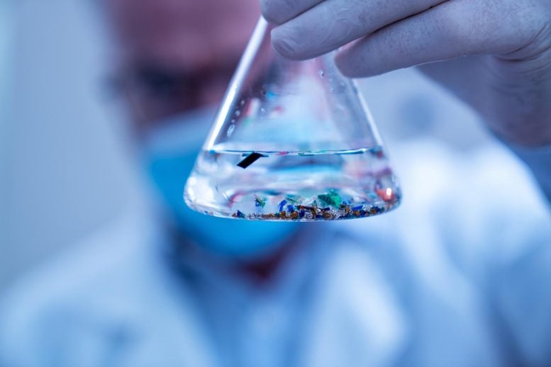 Scientist Examining Small Plastic Particles Laboratory Flask