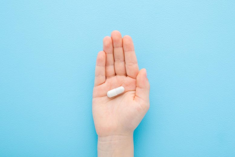 Small Hand Holding White Pill Capsule Medicine