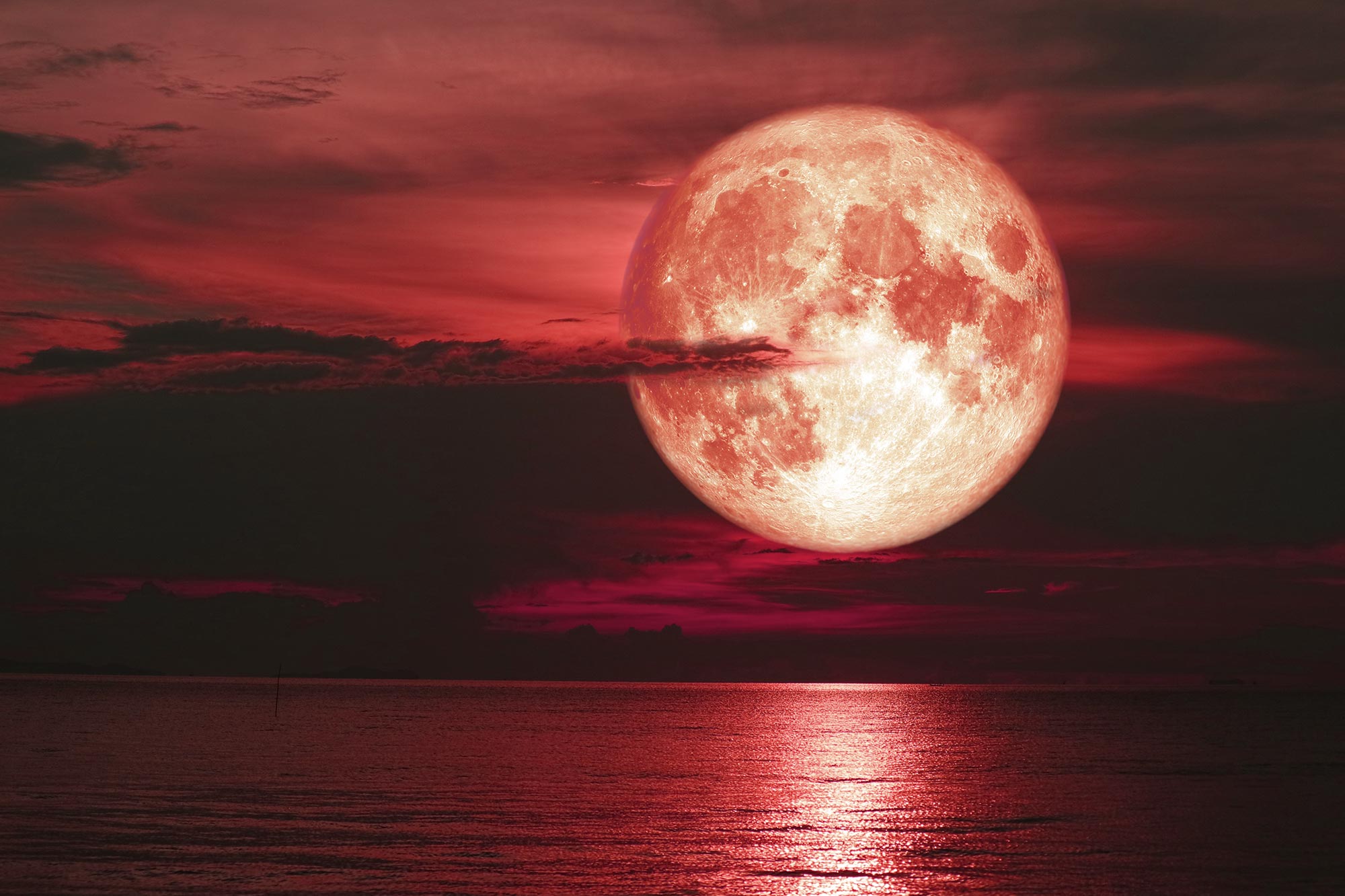 strawberry moon over ocean