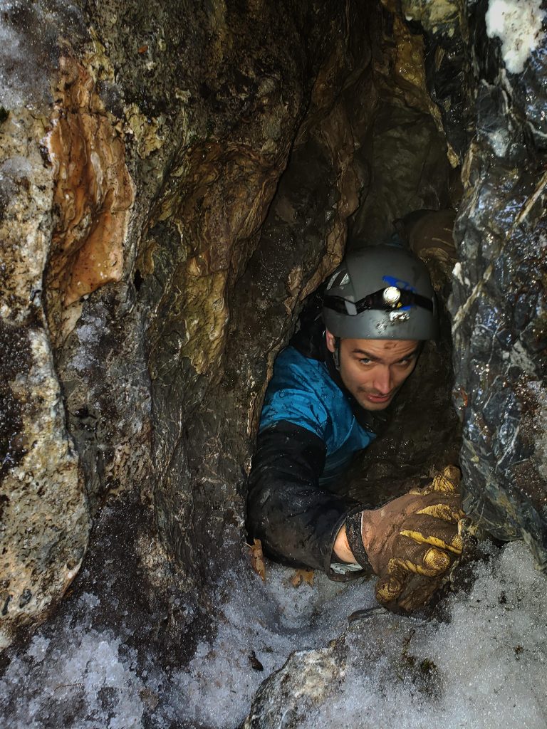 Tyler Faith Squeezes Through the Narrow Opening of an Undisclosed Cave