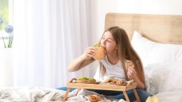 Woman Eating Junk Food in Bed