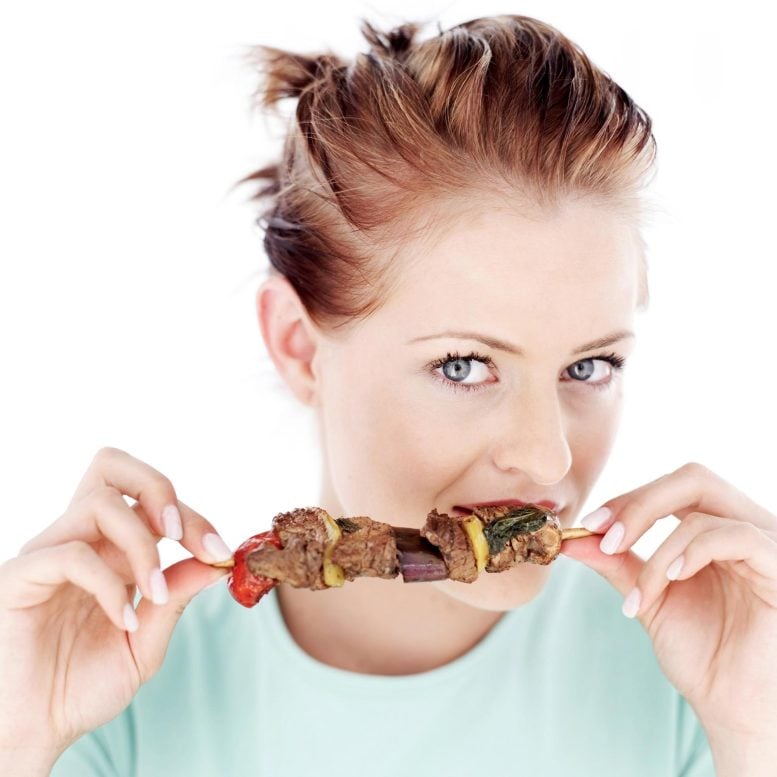 femme mangeant une brochette de viande