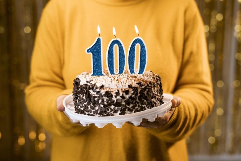 Woman Holding 100 Year Old Birthday Cake