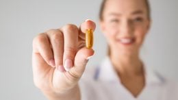 Woman Holding Vitamin Supplement Pill