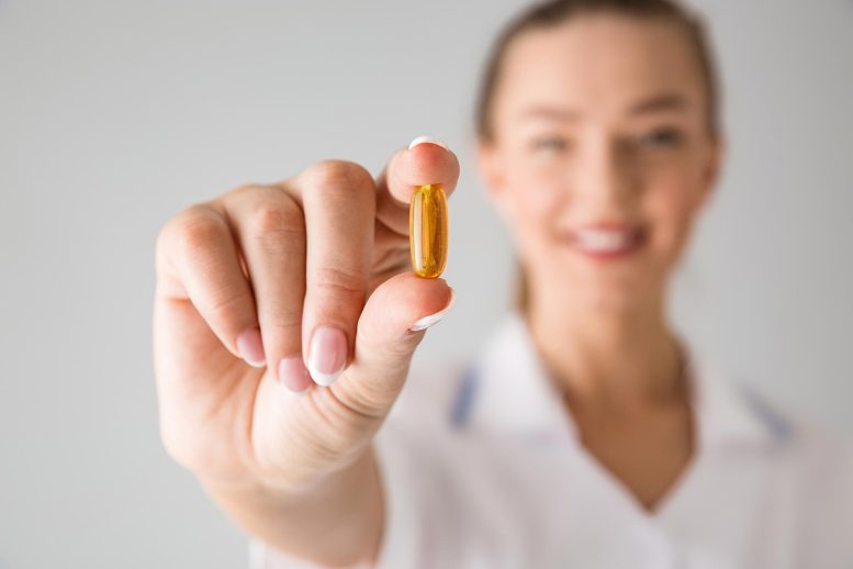 Woman Holding Vitamin Supplement Pill