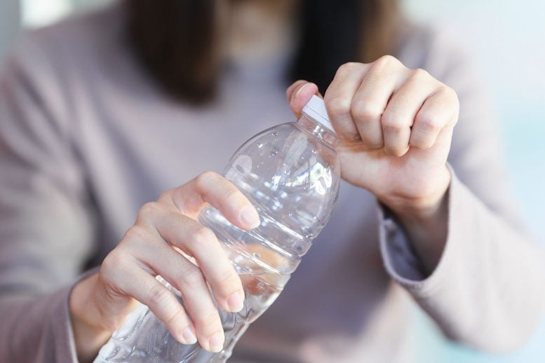 Woman Opening Plastic Water Bottle