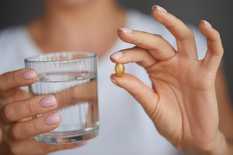 Woman Taking Vitamin D Omega 3 Supplement Pill