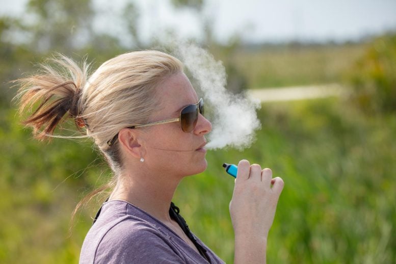 Woman Vaping E-Cigarette Outside Park