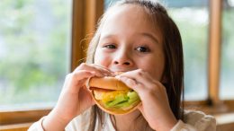 Young Girl Eating Hamburger