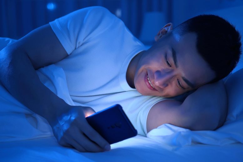 Young Man Smartphone Bed